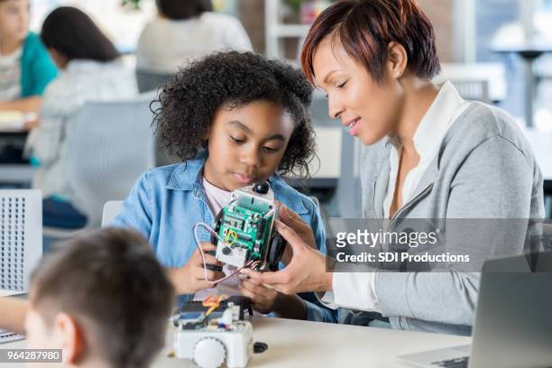 young girl learns to build robot at school - public school building stock pictures, royalty-free photos & images