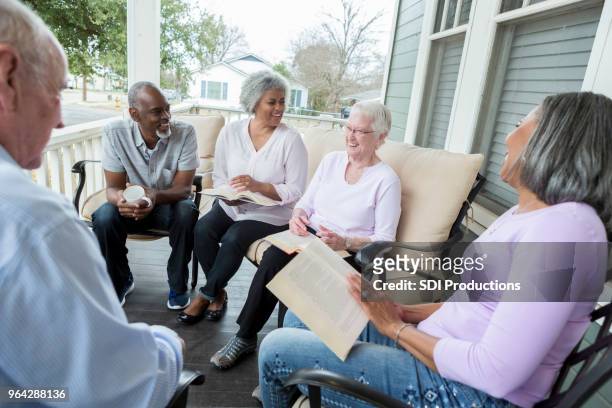 retired adults enjoying book club - senior spirituality stock pictures, royalty-free photos & images