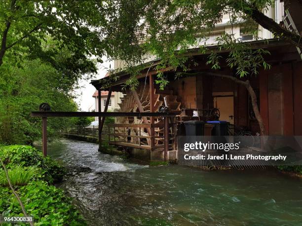 small water wheel near small rapid river and wood building - metzingen stock pictures, royalty-free photos & images