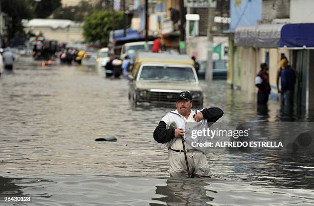 Local resident walks through a flooded street in the Arenal neiborghood of Mexico City on February, 2010. Heavy rains swelled the canal of "Bordo...