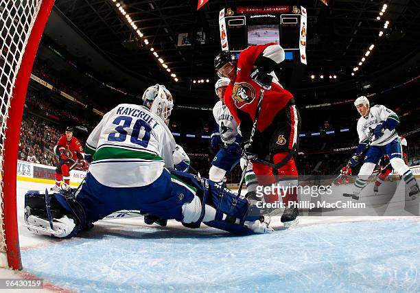 Mike Fisher of the Ottawa Senators digs for a rebound out front of Andrew Raycroft of the Vancouver Canucks in a game at Scotiabank Place on February...