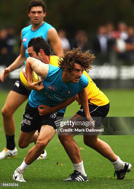 Jaxson Barham of the Magpies attempts to break the tackle from Alan Didak of the Magpies during a Collingwood Magpies intra-club AFL match at Gosch's...