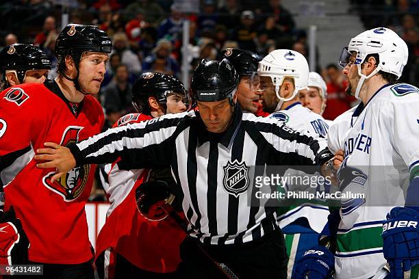 Linesman Jonny Murray gets in between Matt Carkner of the Ottawa Senators and Ryan Kesler of the Vancouver Canucks during a scuffle after the whistle...