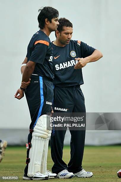 Indian cricketer Subramaniam Badrinath listens to batting tips from Sachin Tendulkar during a practice session in Nagpur on February 5, 2010. The...