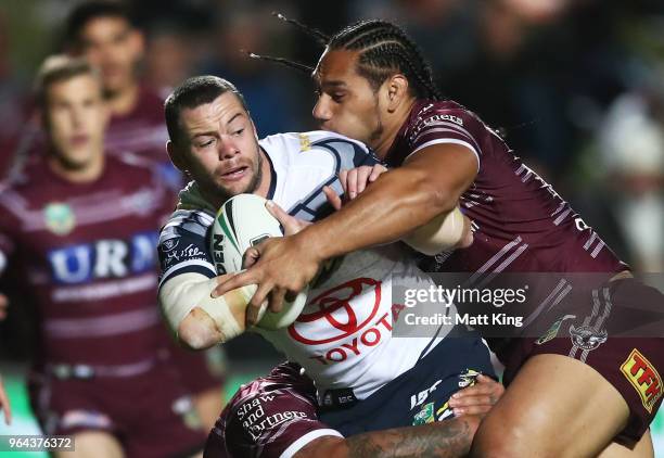 Shaun Fensom of the Cowboys is tackled by Martin Taupau of the Sea Eagles during the round 13 NRL match between the Manly Sea Eagles and the North...