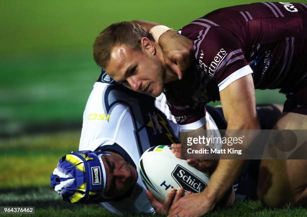 Daly Cherry-Evans of the Sea Eagles is tackled by Johnathan Thurston of the Cowboys during the round 13 NRL match between the Manly Sea Eagles and...