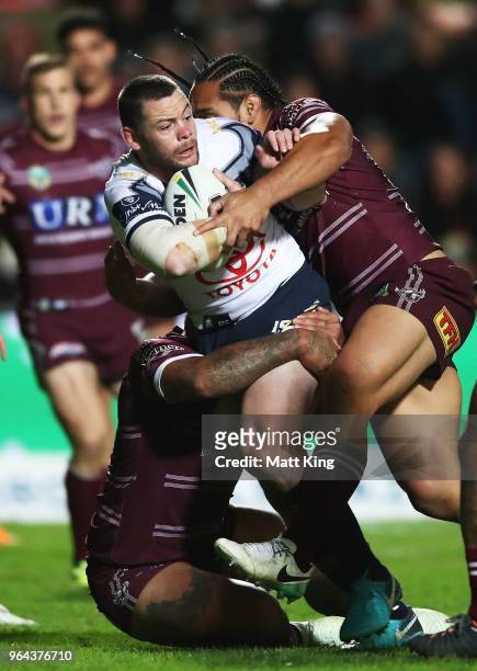 Shaun Fensom of the Cowboys is tackled by Martin Taupau of the Sea Eagles during the round 13 NRL match between the Manly Sea Eagles and the North...