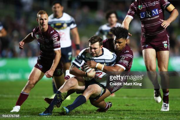 Kyle Feldt of the Cowboys is tackled during the round 13 NRL match between the Manly Sea Eagles and the North Queensland Cowboys at Lottoland on May...