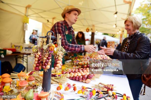 händler verkauft zwiebel zöpfen auf dem traditionellen markt in weimar, deutschland - erntefest stock-fotos und bilder