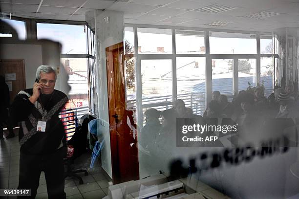 By Isabelle WESSELINGH A recruiter talks on his cell phone as dozens of women wait for a recruitment interview in a labour office on February 4, 2010...