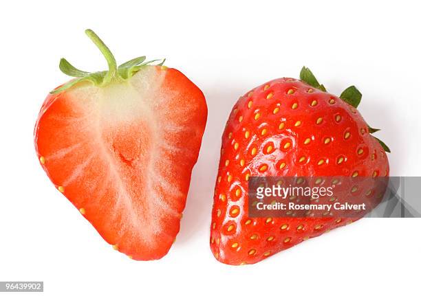 one fresh strawberry cut in half. - strawberry stock pictures, royalty-free photos & images