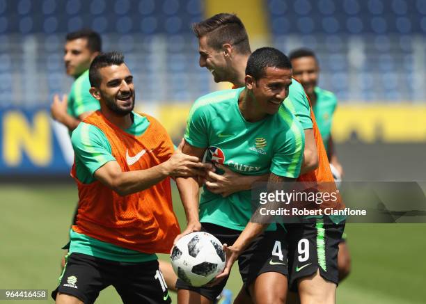 Tim Cahill is tackled by Aziz Behich and Tomi Juric of Australia during an Australia Socceroos training session at NV Arena on May 31, 2018 in Sankt...