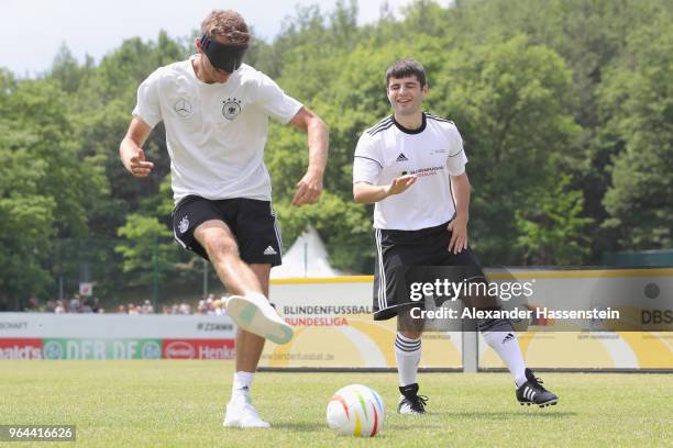 Thomas Mueller plays the ball during a Blind Football demonstration match with natioanl players of the German national Blind Football team at...