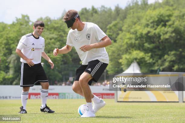 Thomas Mueller plays the ball during a Blind Football demonstration match with natioanl players of the German national Blind Football team at...