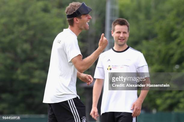 Thomas Mueller smiles with Alexander Fangmann during a Blind Football demonstration match with national players of the German national Blind Football...