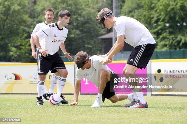 Thomas Mueller and Matthias Ginter attend a Blind Football demonstration match with national players of the German national Blind Football team at...