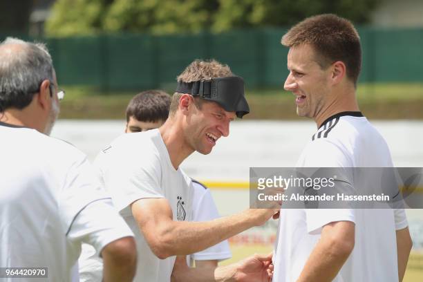 Thomas Mueller smiles with Alexander Fangmann during a Blind Football demonstration match with national players of the German national Blind Football...