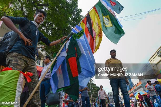 This photographs taken on May 30 shows a Bangladeshi vendor displaying national flags of the countries that are competing in the forthcoming 2018...