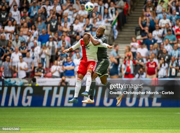 Teal Bunbury of the New England Revolution and Kendall Waston of the Vancouver Whitecaps go for a header at BC Place on May 26, 2018 in Vancouver,...