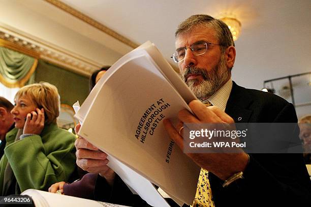 Sinn Fein's Gerry Adams looks at a copy of the Agreement during a press conference after a deal was announced concerning Northern Ireland's...