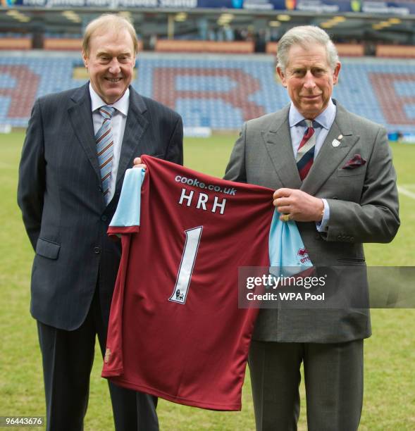 Prince Charles, Prince of Wales poses with Burnley Chairman Barry Kilby while holding a Burnley football shirt as meets representatives of Burnley...