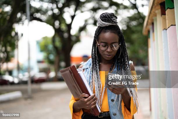 afro student/teacher on the move with mobile - portrait of teacher and student stock pictures, royalty-free photos & images