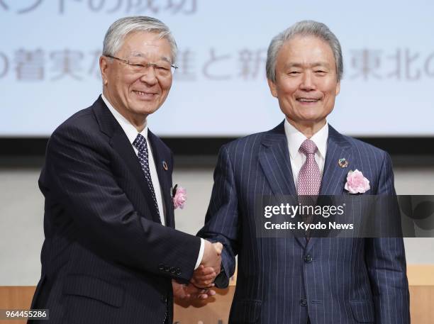 New Japan Business Federation Chairman Hiroaki Nakanishi shakes hands with his predecessor Sadayuki Sakakibara at a general meeting of the business...