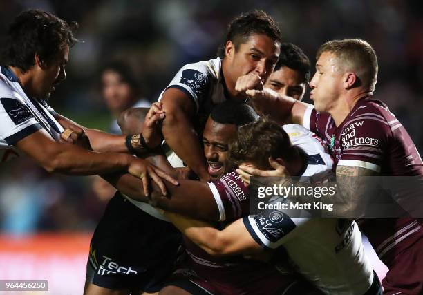 Akuila Uate of the Sea Eagles is tackled during the round 13 NRL match between the Manly Sea Eagles and the North Queensland Cowboys at Lottoland on...