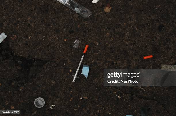 Used needles and other drug paraphilia litter the sidewalk at a homeless encampment in the Kensington section of Philadelphia on May 30, 2018.