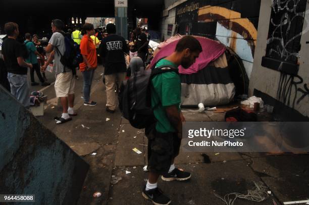 Heroin addict nods amid the chaos of the eviction of a homeless encampment in the Kensington section of Philadelphia on May 30, 2018.