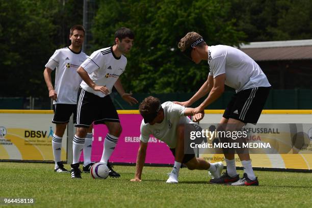 Members of the German football national blind team Alexander Fangmann and Ali Pektas, Germany's forward Thomas Müller and Germany's midfielder...