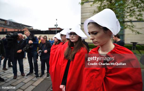 Protestors dressed as hand maidens stand as abortion rights campaign group ROSA, Reproductive Rights Against Oppression, Sexism and Austerity...