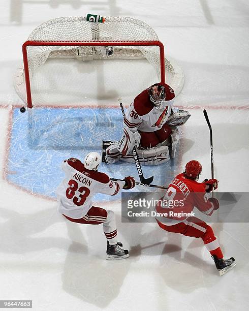 Justin Abdelkader of the Detroit Red Wings tips the puck wide of goaltender Ilya Bryzgalov of the Phoenix Coyotes as teammate Adrian Aucion defends...
