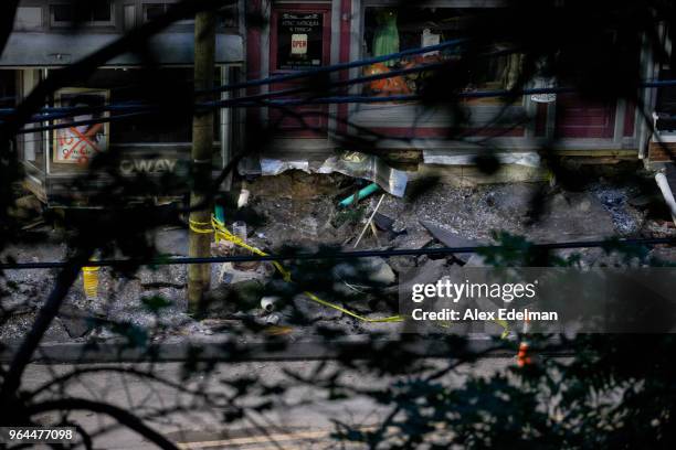 Sink hole is seen on Main Street as work crews attempt to secure structures several days after devastating flash flooding caused an evacuation,...