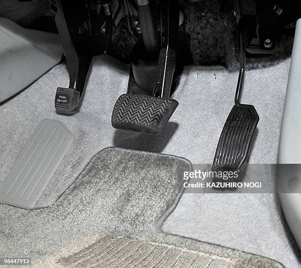 This picture shows a brake pedal and an accelerator of the latest Toyota Prius hybrid vehicle on display at the company's showroom in Tokyo on...