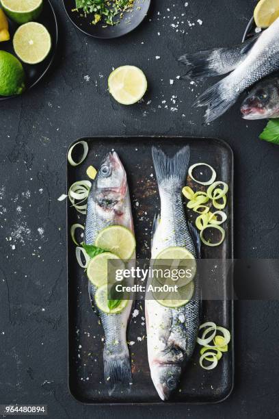 raw fish with lime and herbs on a baking tray - fish dinner stock pictures, royalty-free photos & images