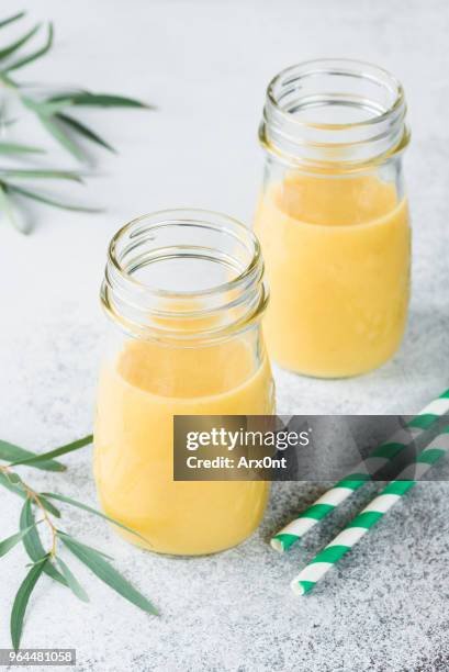 tropical fruit juice or smoothie in bottle - mango juice stockfoto's en -beelden