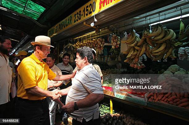 Costa Rican presidential candidate for the Citizen Action Party, Otton Solis , shakes hands with a supporter during a visit to the Central Market of...