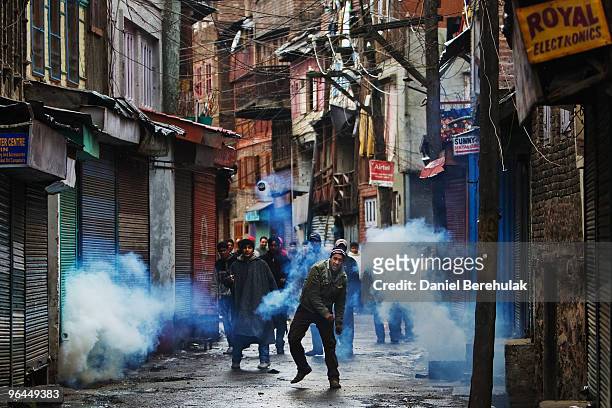 Kashmiri muslim throws back a can of tear gas shot by Indian police on February 05, 2010 in Srinagar, Kashmir, India. Fresh protests erupted today...