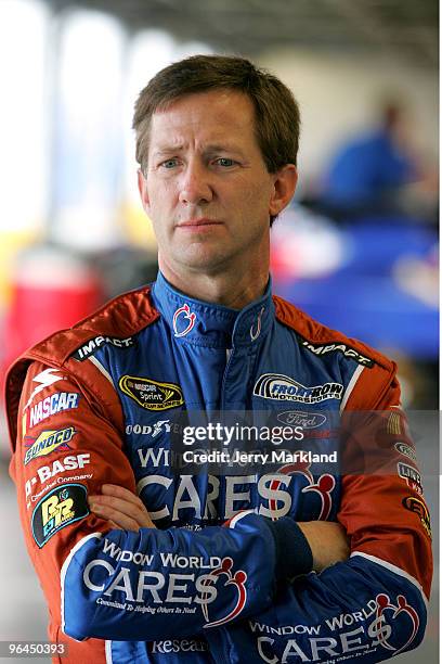 John Andretti, driver of the Window World Cares Ford, stands in the garage area during practice for the NASCAR Sprint Cup Series Daytona 500 at...
