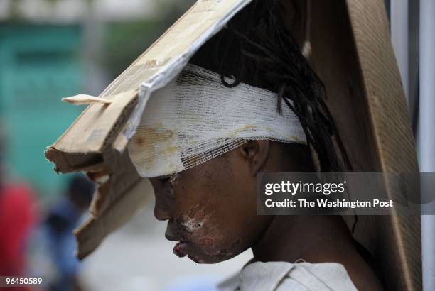 Injured survivor Marie France Coartin drives by with a religious order, Orden de Malta from the D.R. As Haitians pray at Cathedral Notre Dame which...