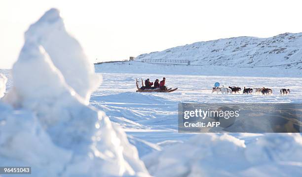 Canada's Finance Minister Jim Flaherty rides in a dogsled across a frozen Frobisher Bay off Iqaluit, Nunavut, Canada, February 5, 2010 as Canada...