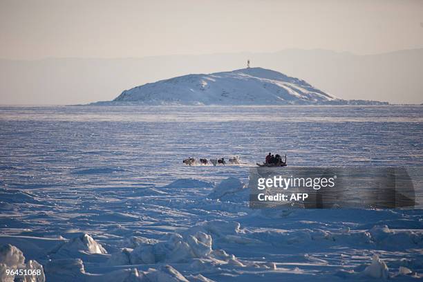 Canada's Finance Minister Jim Flaherty rides in a dogsled across a frozen Frobisher Bay off Iqaluit, Nunavut, Canada, February 5, 2010 as Canada...