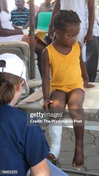 Dr. Suzie Miller treats a girl with a leg injury at a makeshift clinic at Hopital Saint Michel in Jacmel, Haiti.