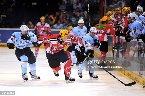 Thomas Oppenheimer of Frankfurt is challenged by Alexander Barteis and Alexander Barta of Hamburg during the DEL match between Hamburg Freezers and...