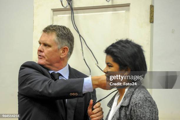 Murder accused Jason Rohde uses a police officer as a model to demonstrate how he found his wife Susans body during his trial at the Western Cape...