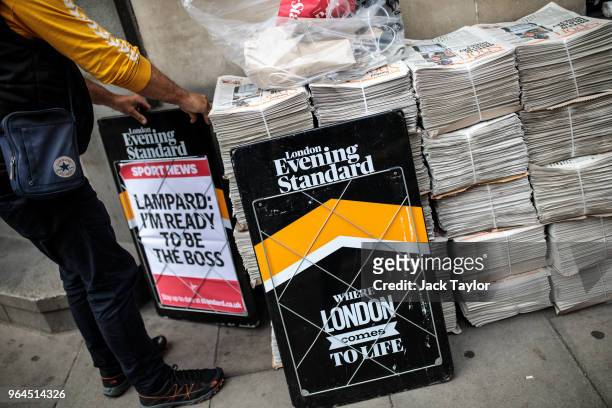 An employee moves headline boards around stacks of the London Evening Standard newspaper outside St. James's Park Underground station on May 31, 2018...