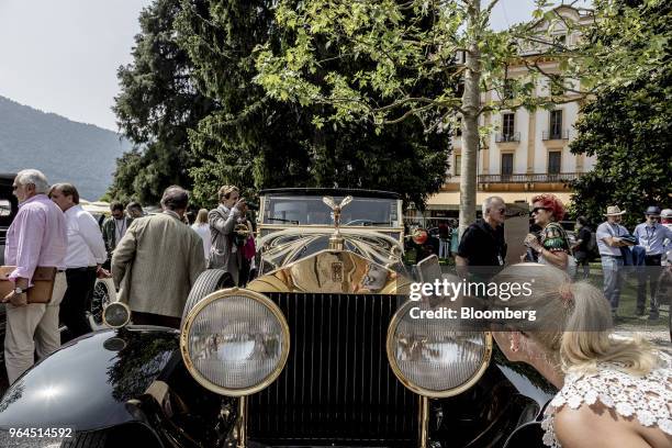 Guest takes a photograph of a 1929 Rolls-Royce Motor Cars Ltd. Phantom automobile as it stands on display at the 2018 Concorso D'Eleganza at Villa...