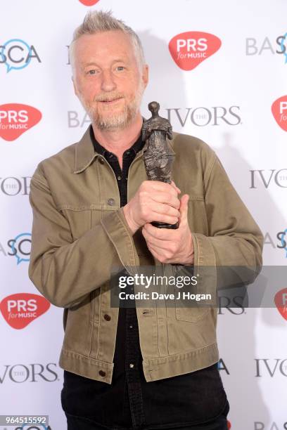 Billy Bragg with the Outstanding Contribution to British Music Award, poses in the winner's room during the Ivor Novello Awards 2018 at Grosvenor...