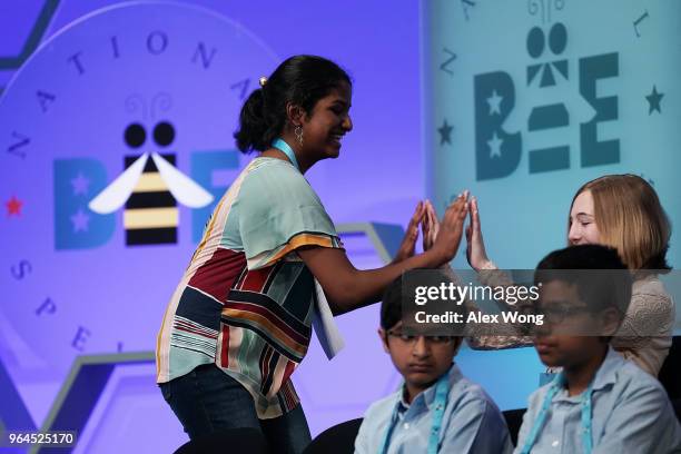 Nilla Rajan of Athens, Ohio, celebrates with fellow spellers after she correctly spelled her word during round four of the 91st Scripps National...